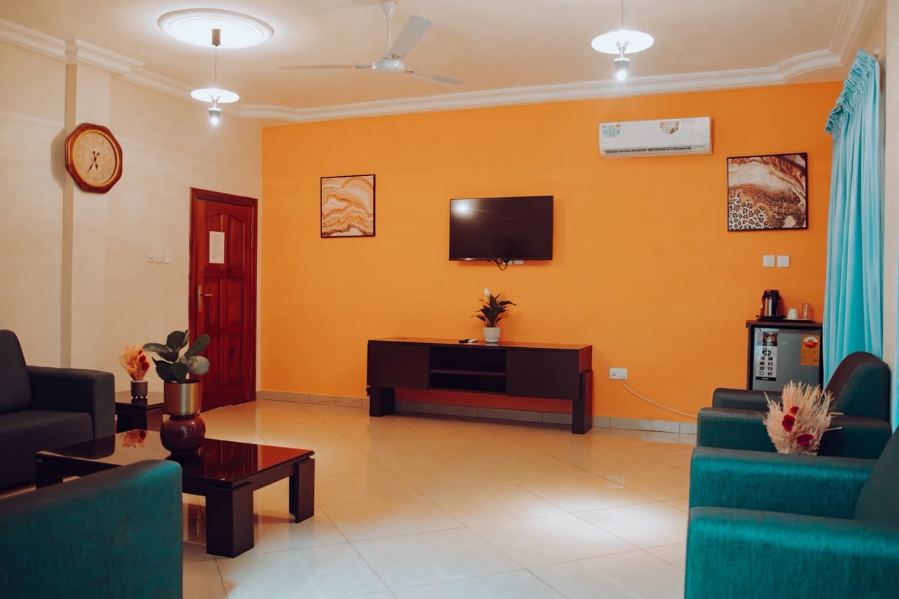 Suite sitting room with orange feature wall and TV